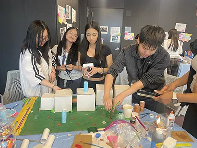 high school students work on their model of the future of school. 