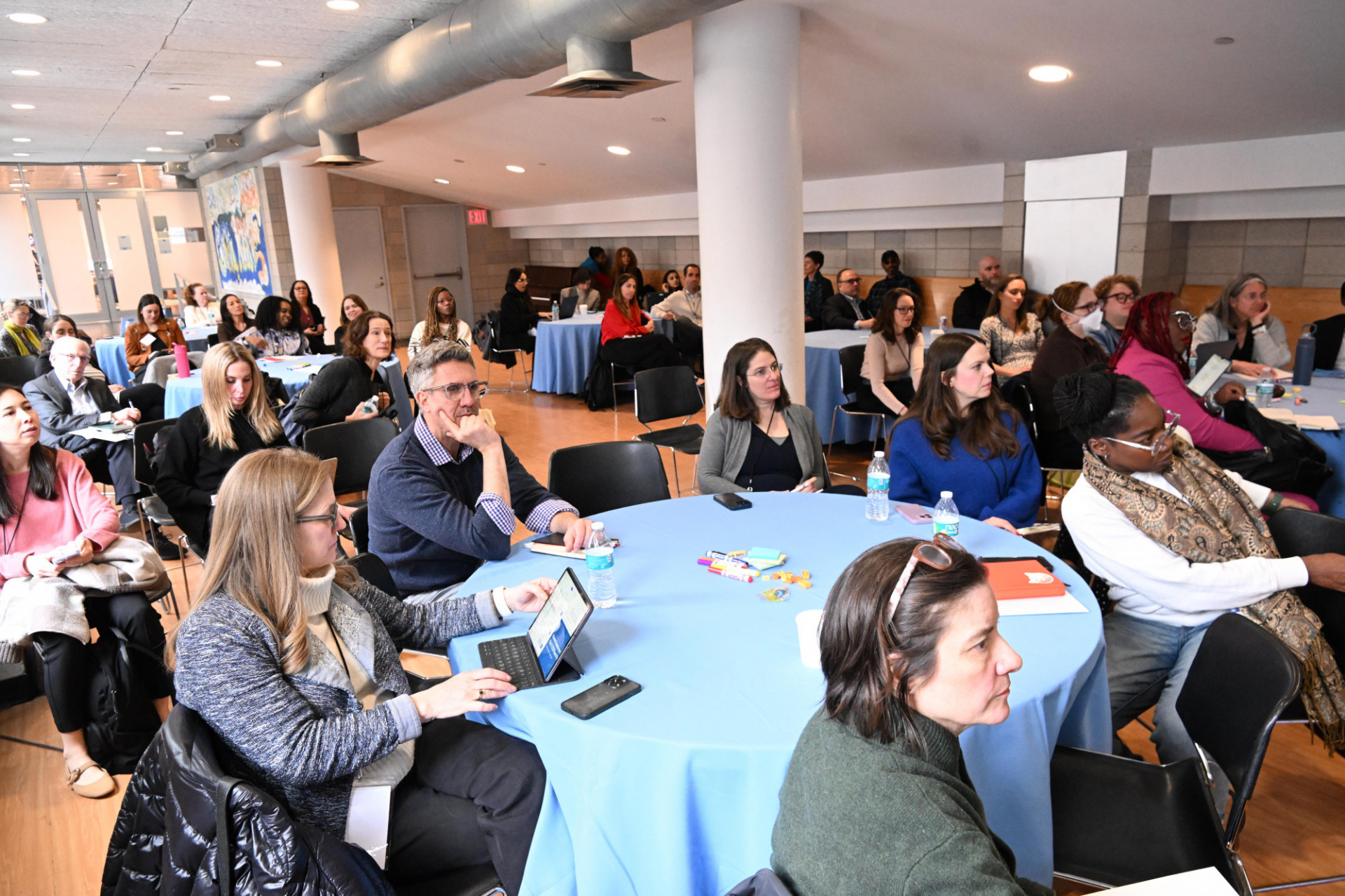 a room of people sitting at round tables