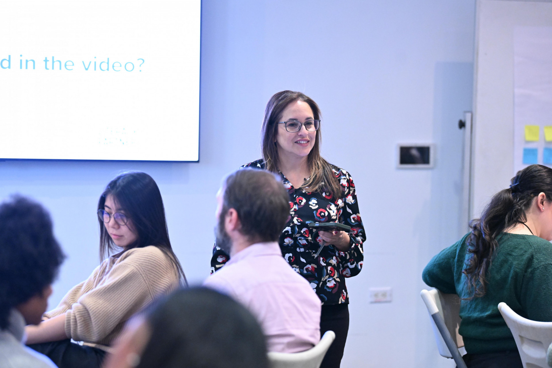 a woman walking through a group seated at tables