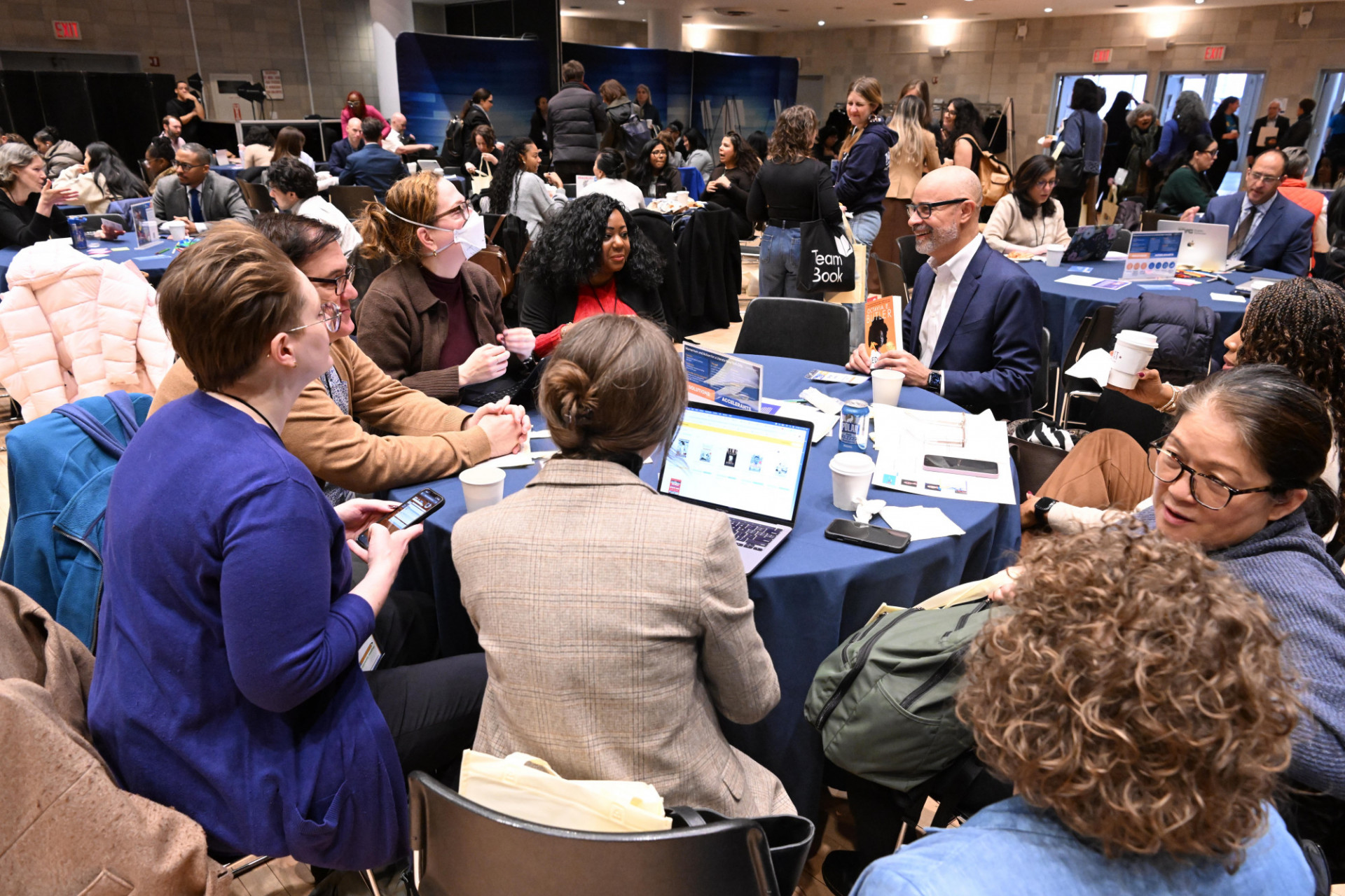 a table of people working and talking with one another