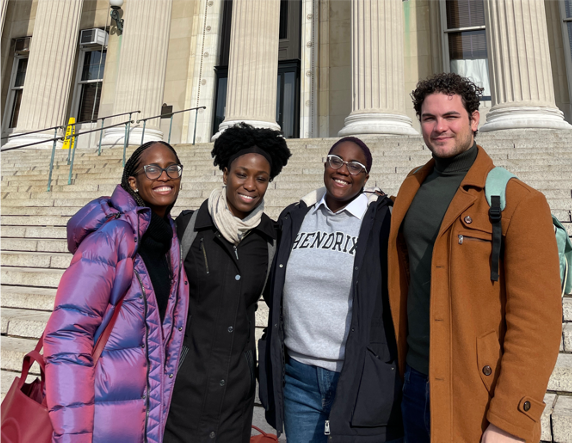 Four members of a project team standing in front of the Columbia University library