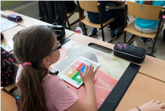 Elementary school-aged, white female student in a classroom with a tablet
