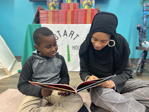 child and reacher reading in a classroom