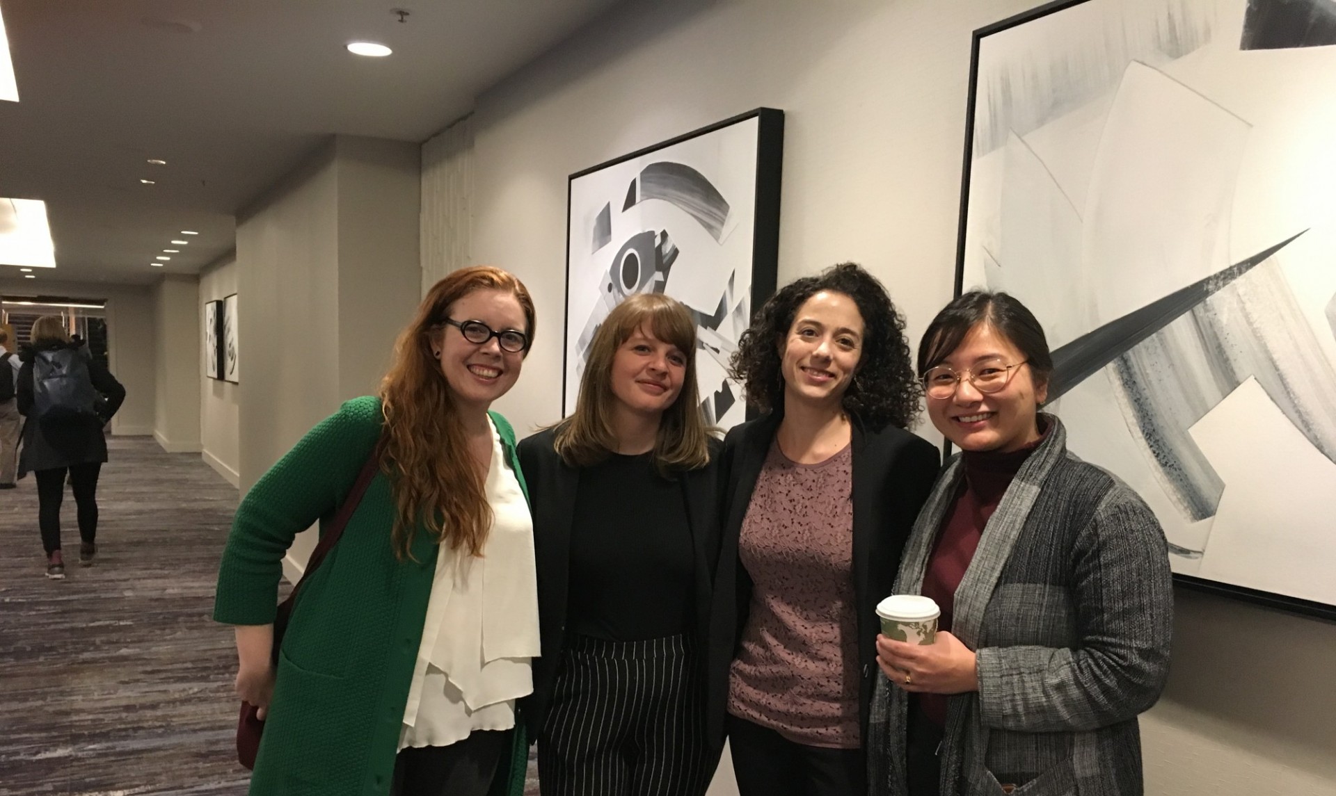 Two students and two CPRL staff members posing for a picture while at a conference 