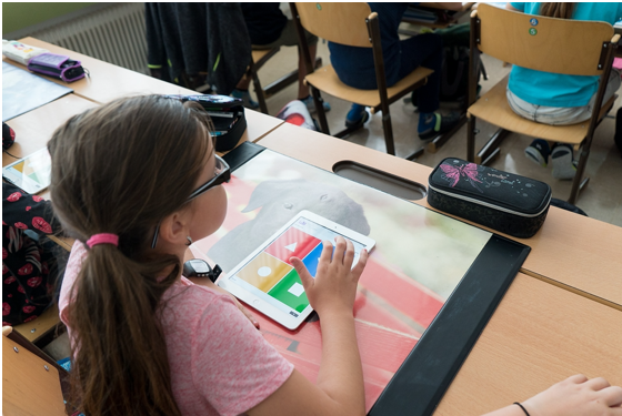 Elementary school-aged, white female student in a classroom with a tablet