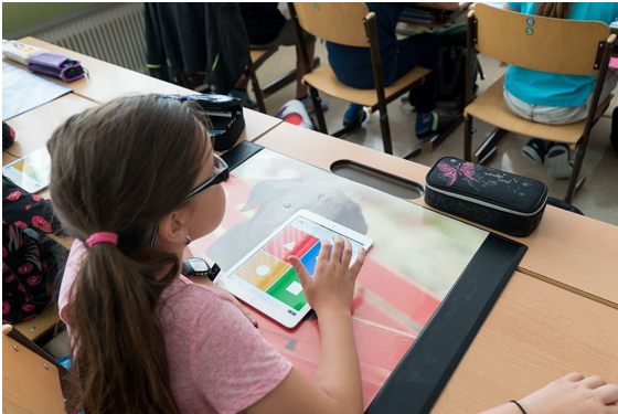 Evidence-based instructional materials and professional learning Elementary school-aged, white female student in a classroom with a tablet